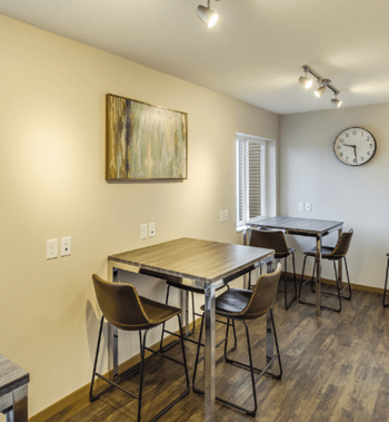 a dining room with a table and chairs and a clock on the wall at Campus Park, Duluth, 55811